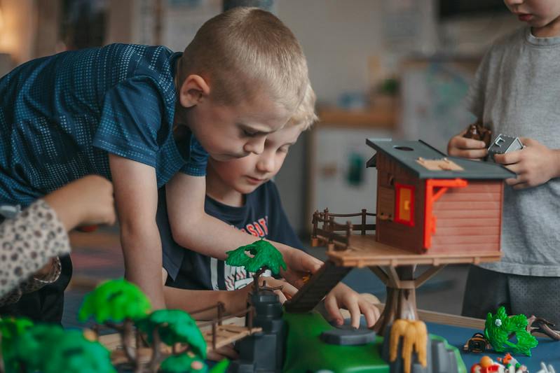 Children playing with a toy treehouse playset