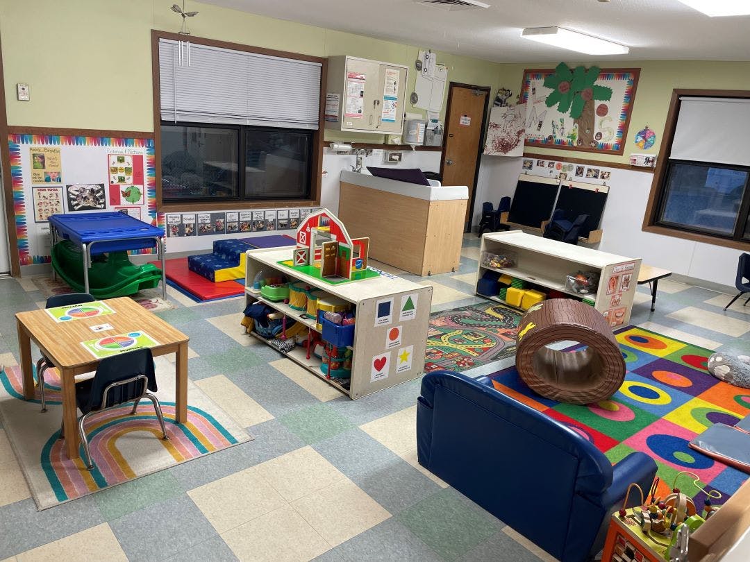 Colorful playroom or classroom with various toys, small tables, and rugs