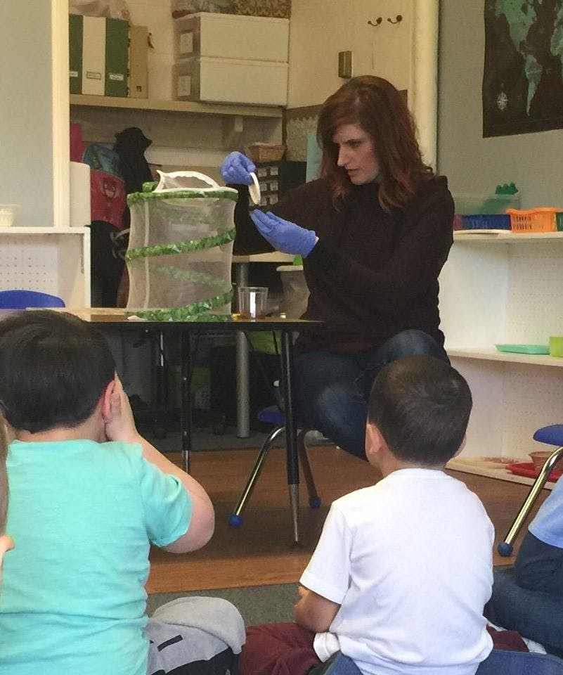 Person in gloves demonstrating to children