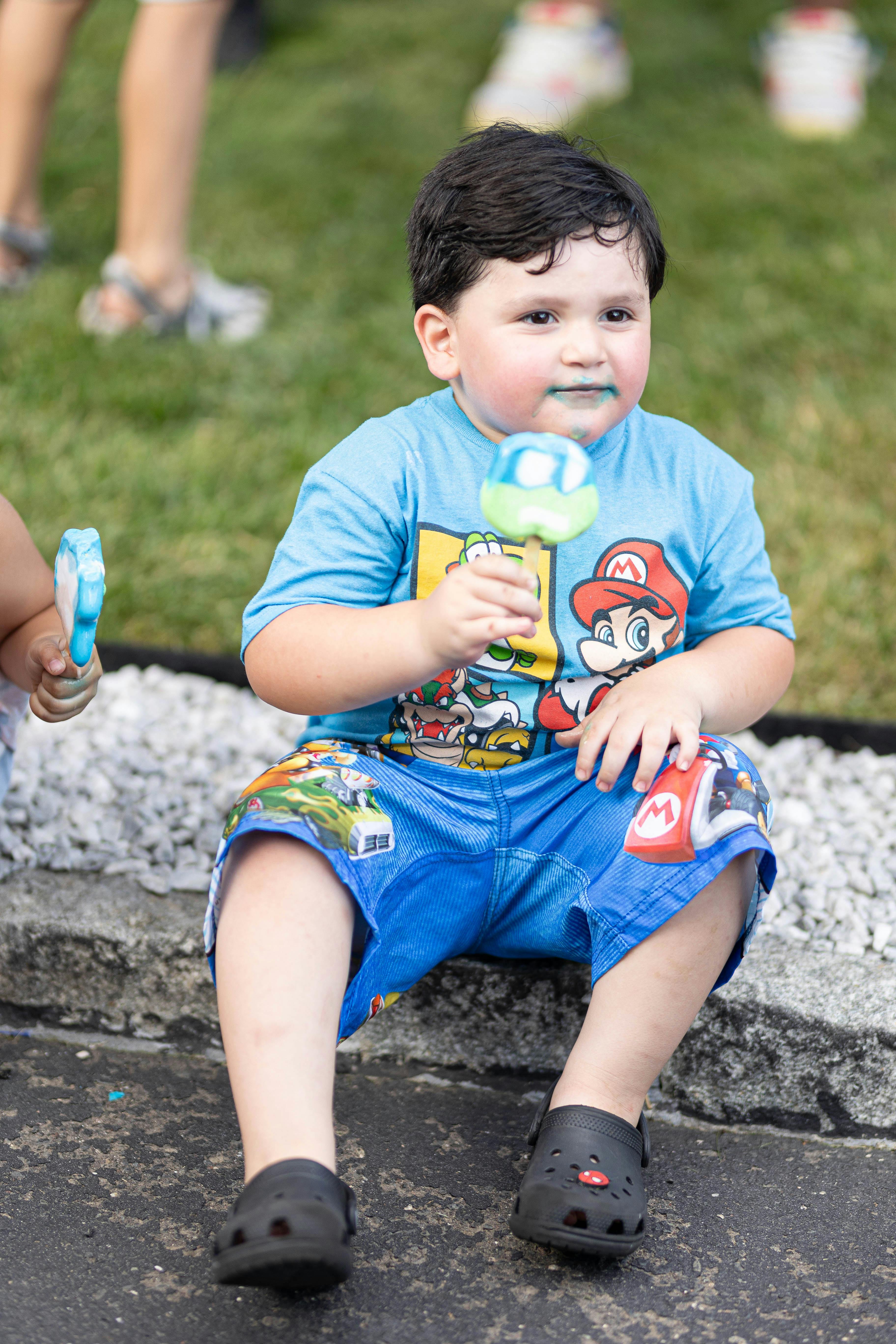 Child sitting and holding a popsicle