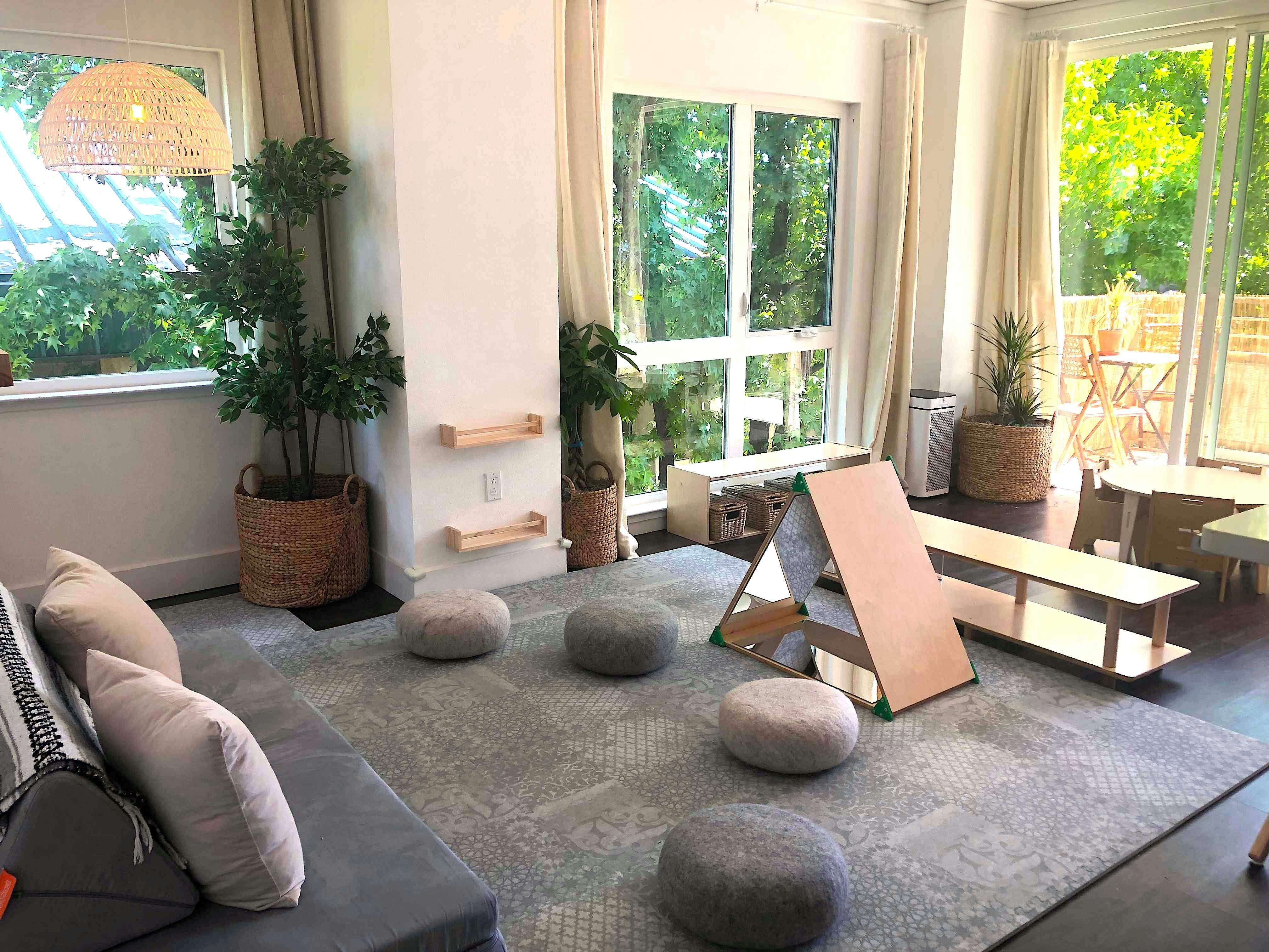 Indoor play area with floor cushions and wooden play equipment