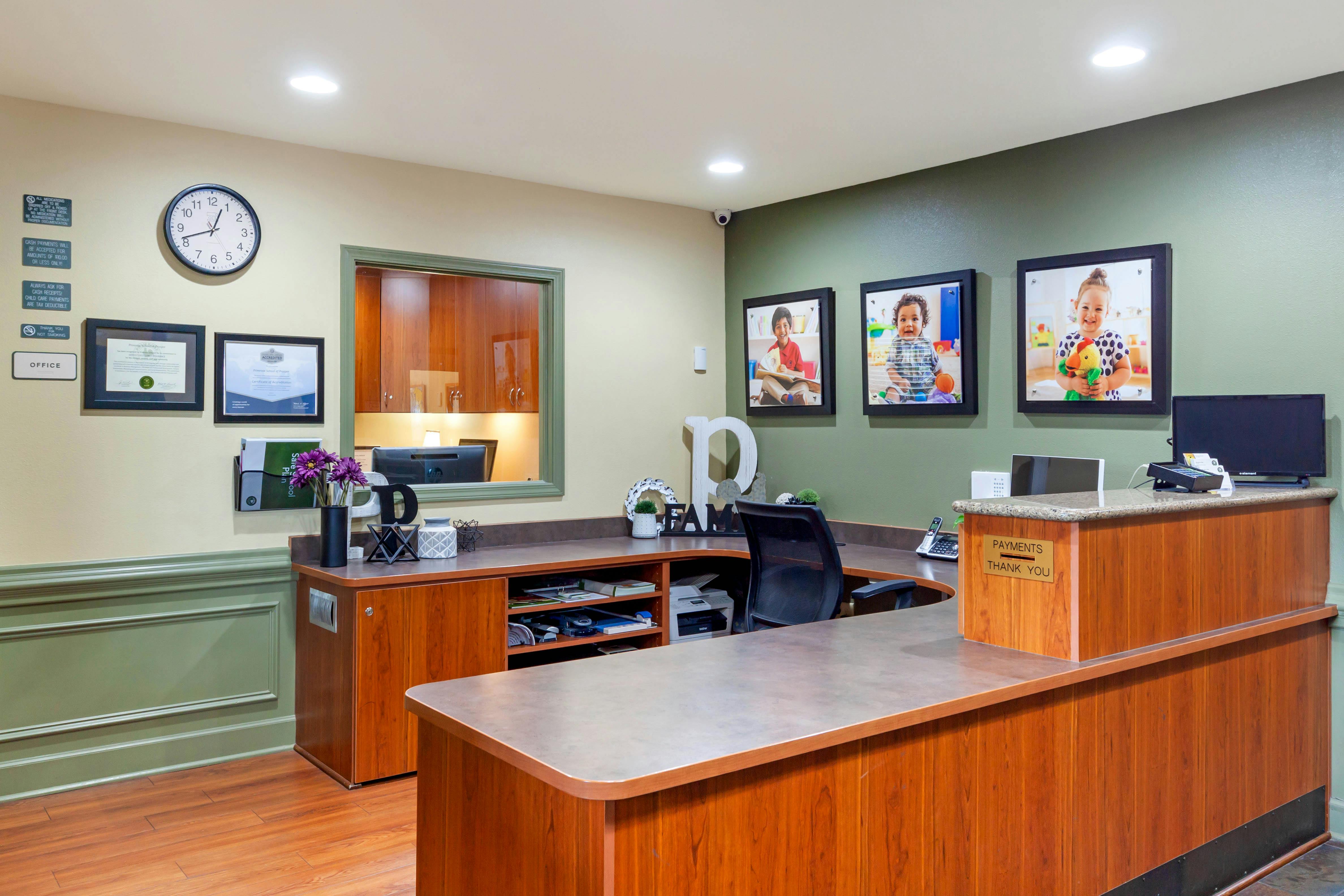 Reception desk with three framed pictures of children on the wall