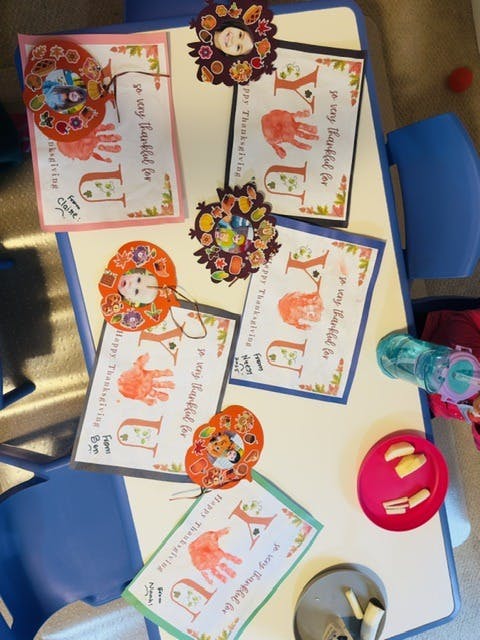 Child-made Thanksgiving art projects with handprints on a table