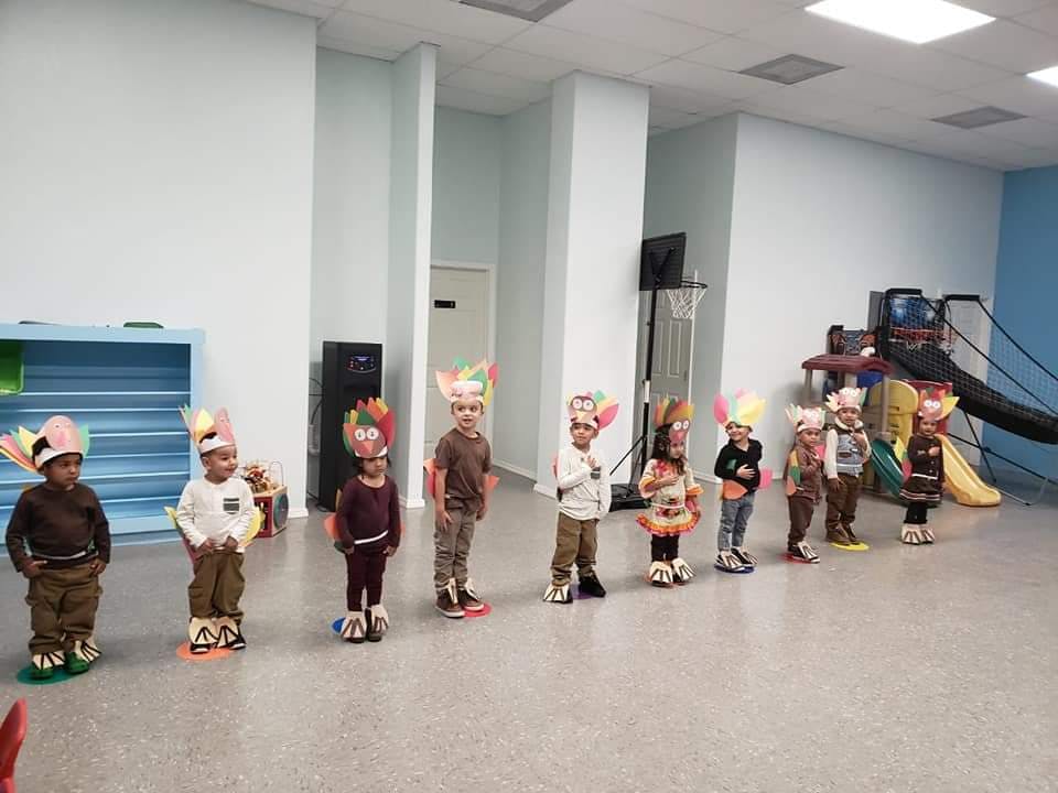 Children in a classroom wearing paper crowns