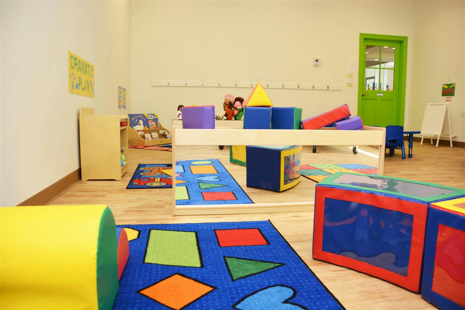 Playroom with colorful soft blocks, rugs, and a low wooden table