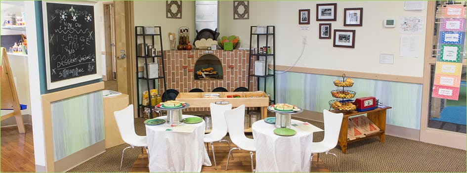 Room with small tables, chairs, and a brick fireplace