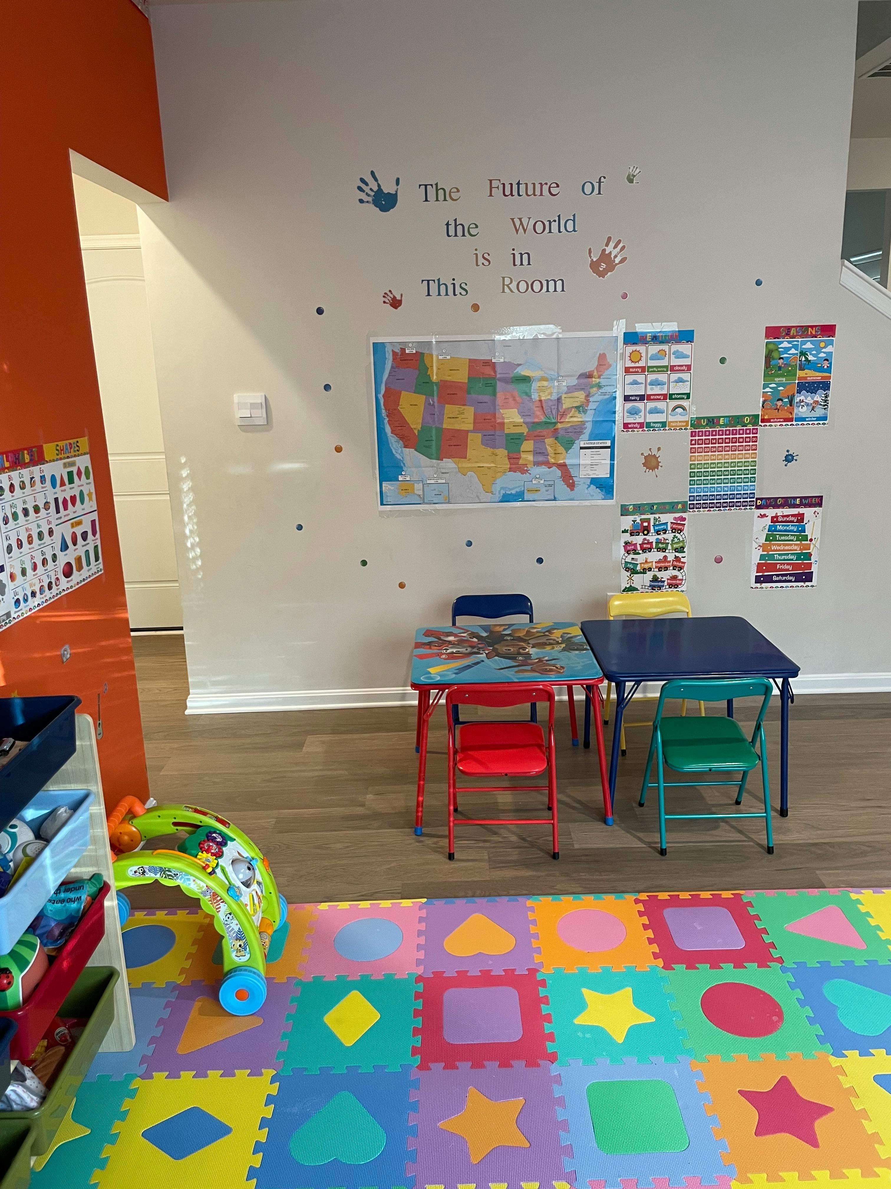 Classroom with colorful floor mats, small tables, and a US map on the wall