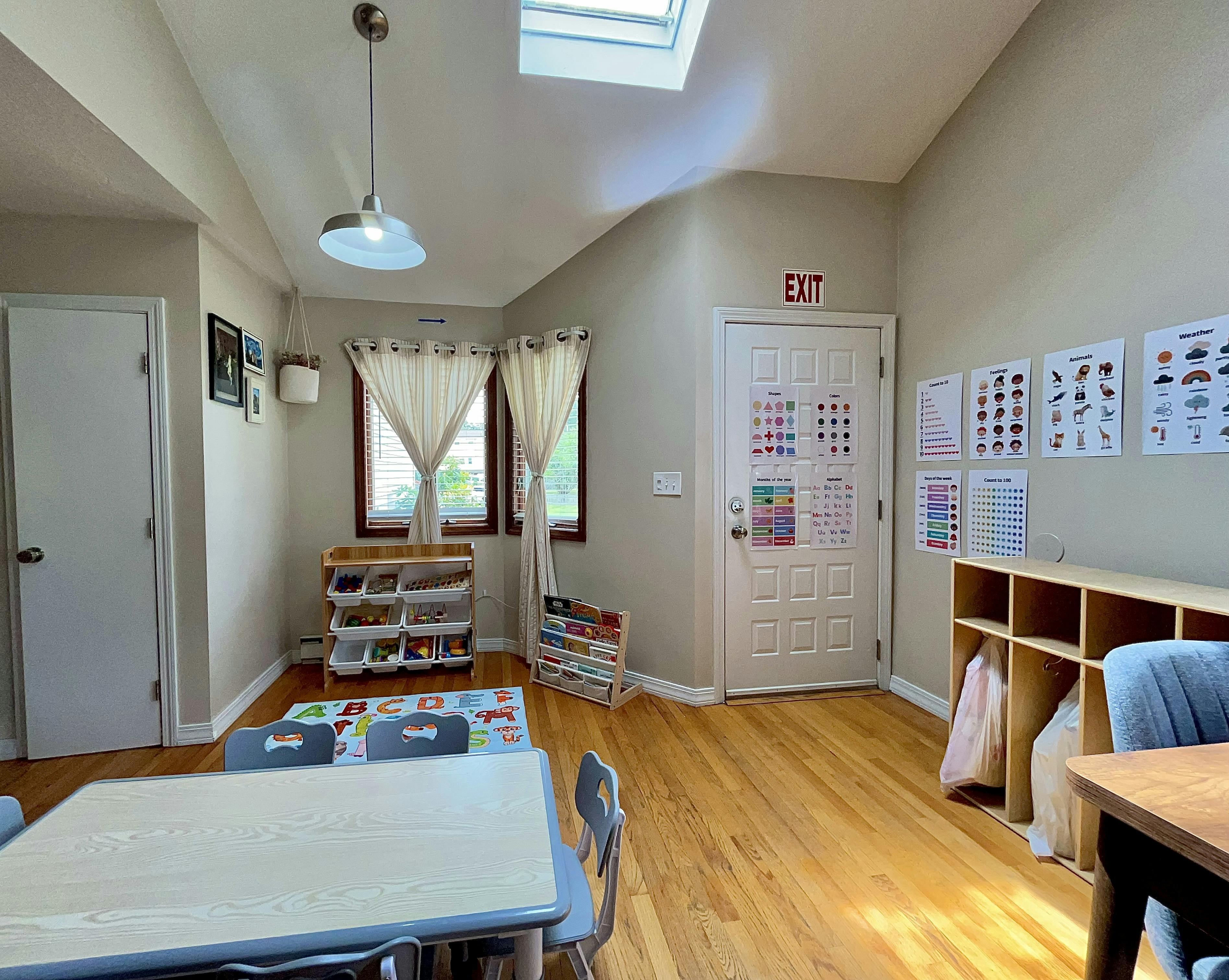 Classroom with tables, chairs, shelves, and educational posters