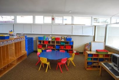 Empty classroom with small blue table and colorful chairs