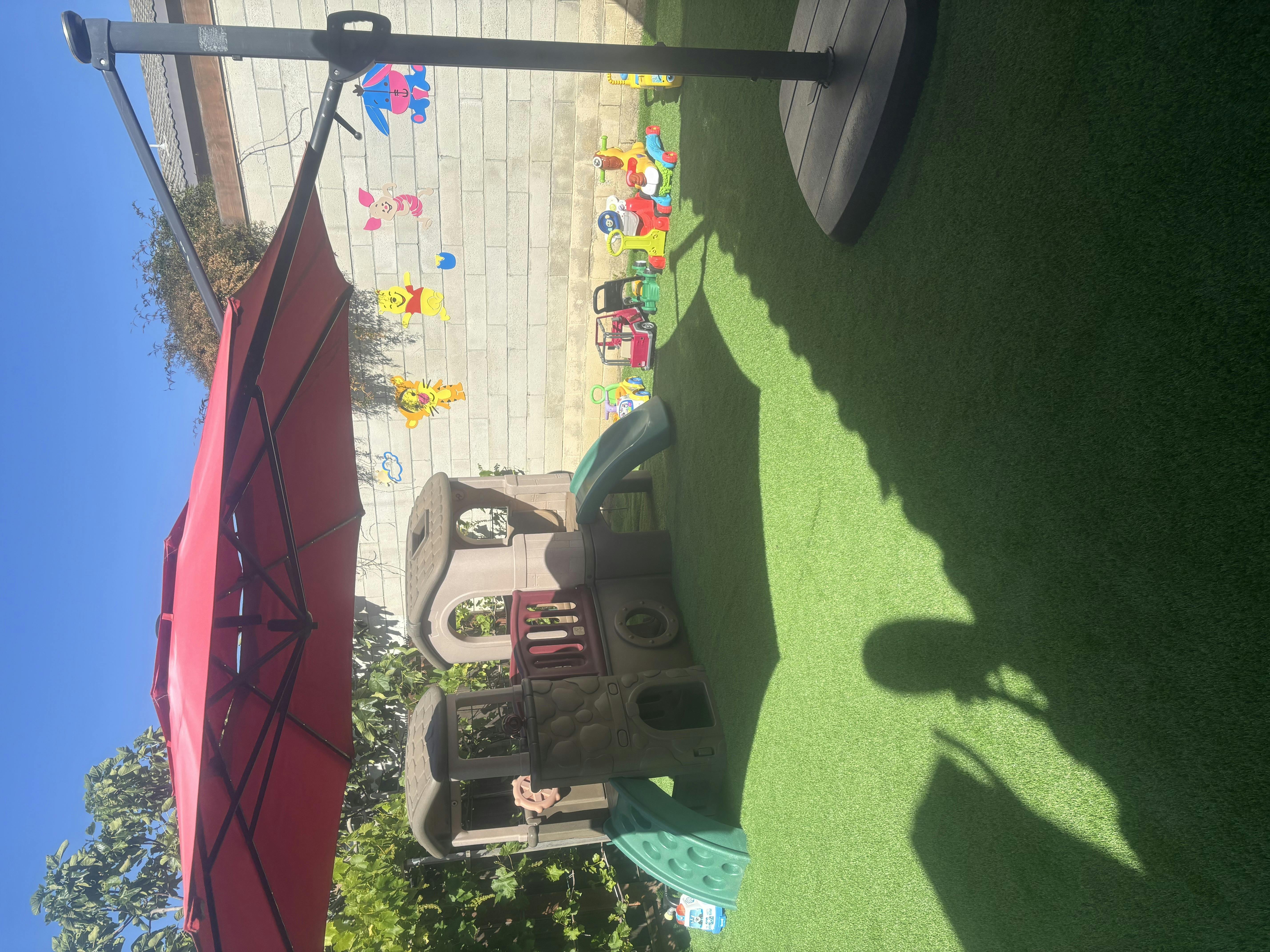 Red umbrella over a playground with a child