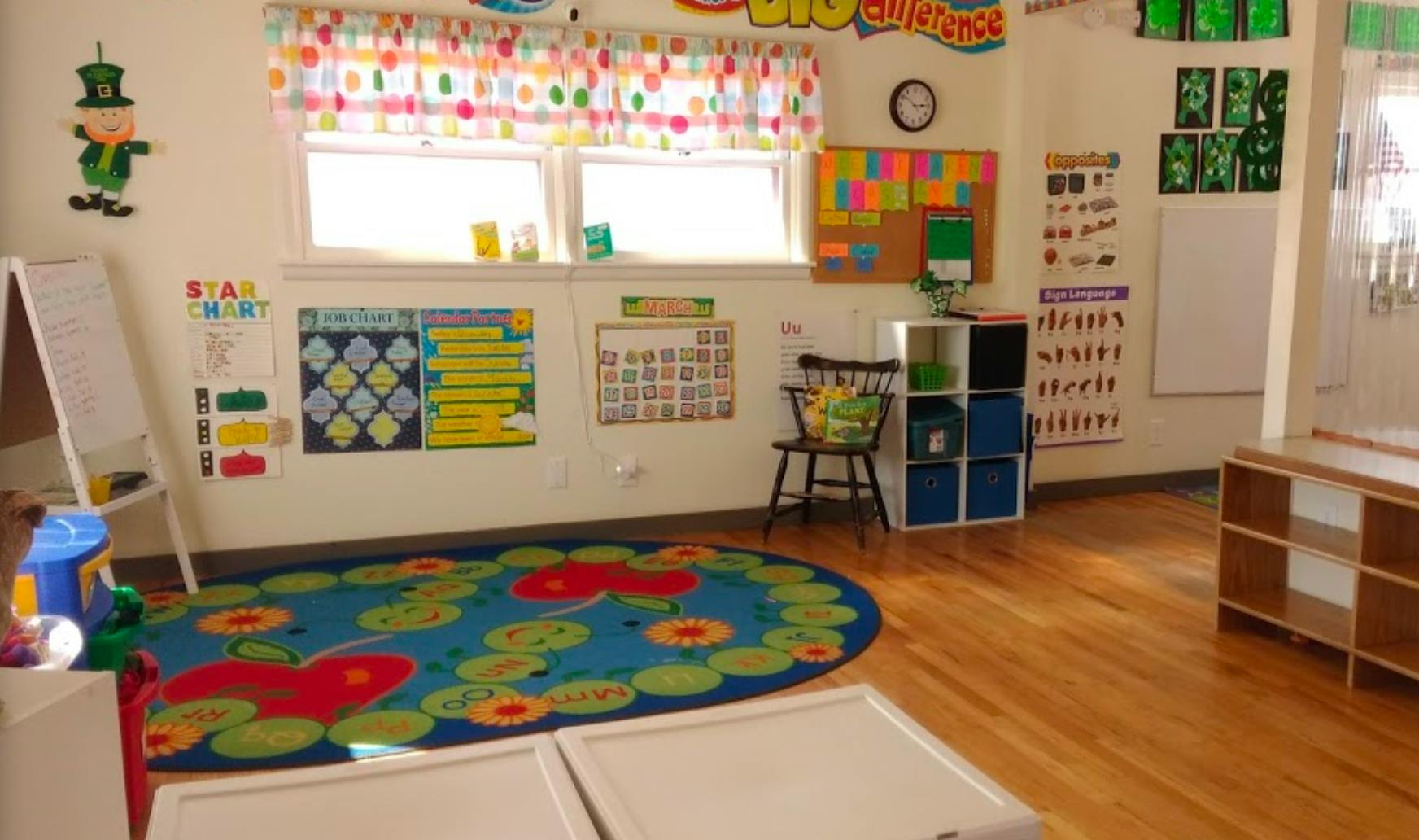 Classroom with a colorful rug, whiteboard, and educational posters