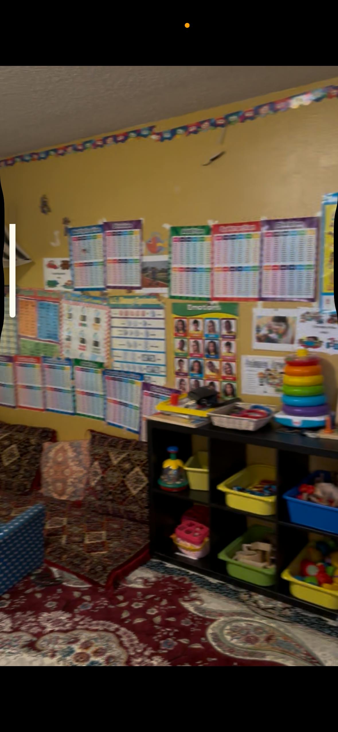 Classroom wall with many colorful educational charts and a toy shelf