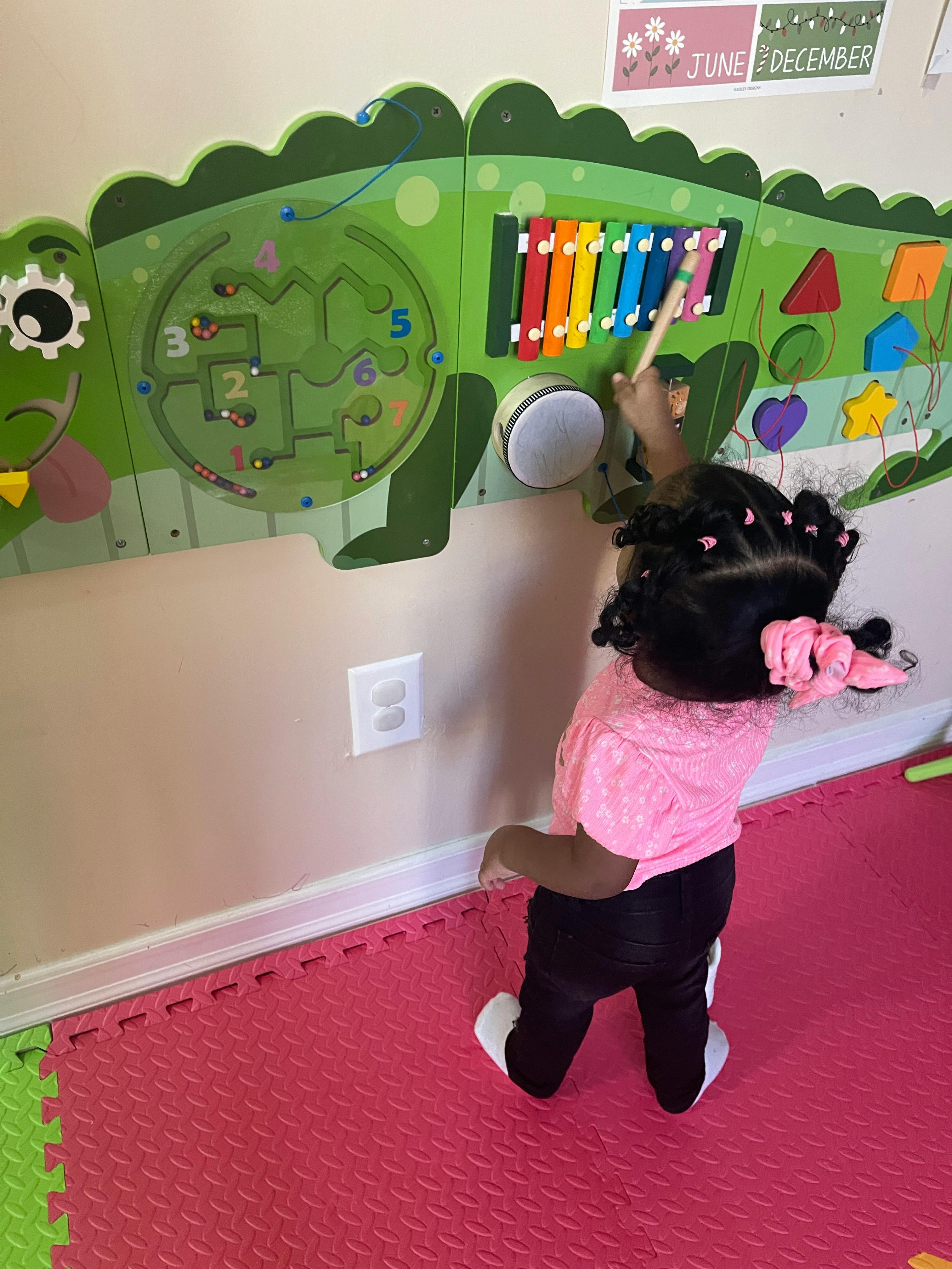 Child playing with a wall-mounted activity board