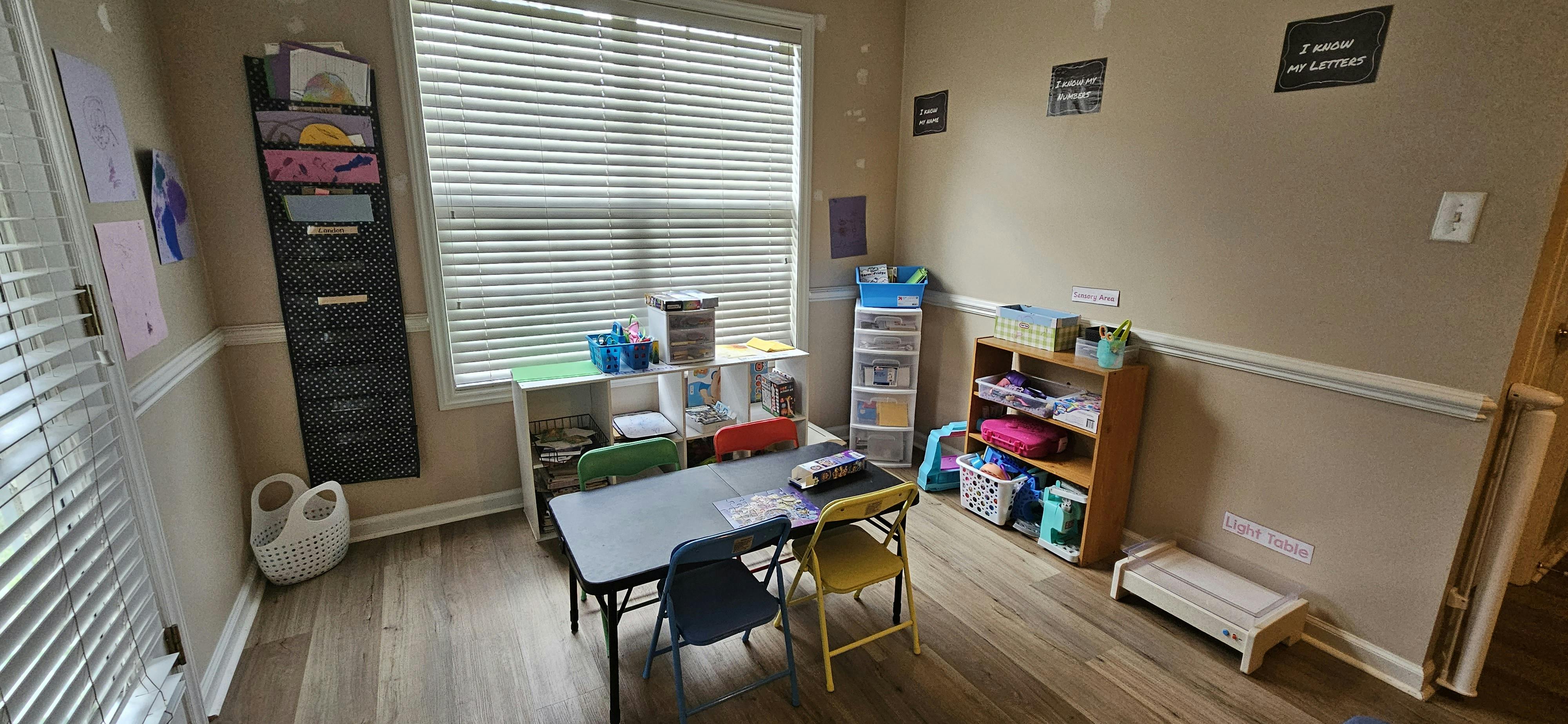 Classroom with a table and chairs, storage shelves, and a window