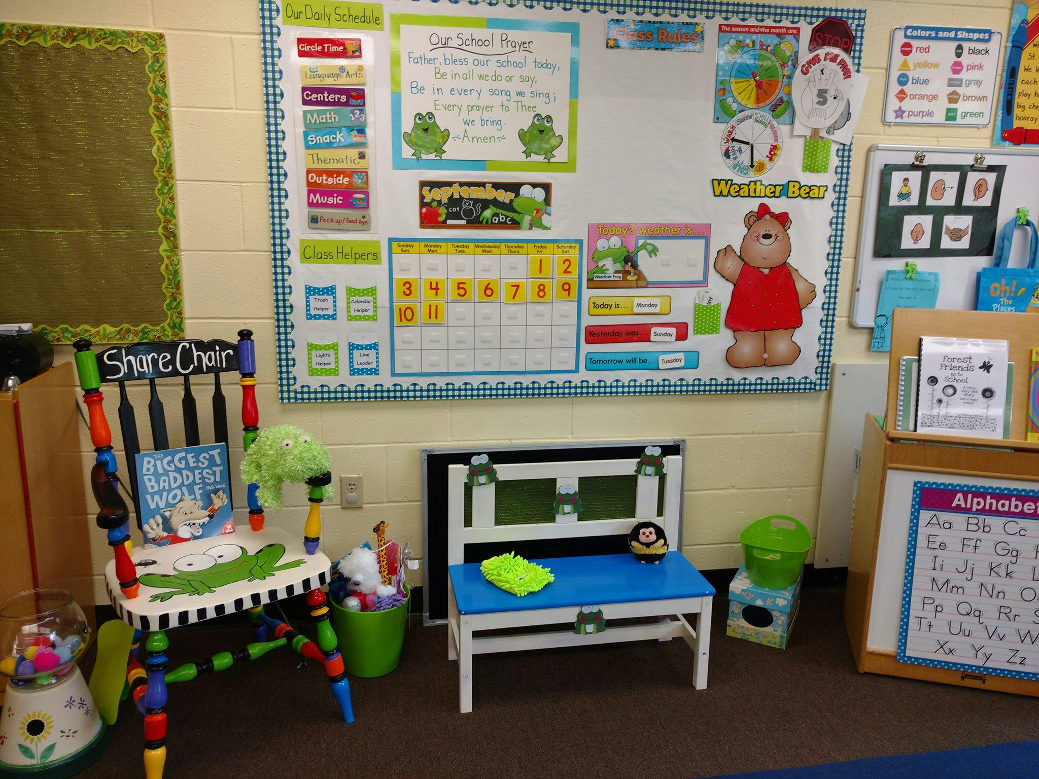 Classroom with a colorful chair, whiteboard, and small bench