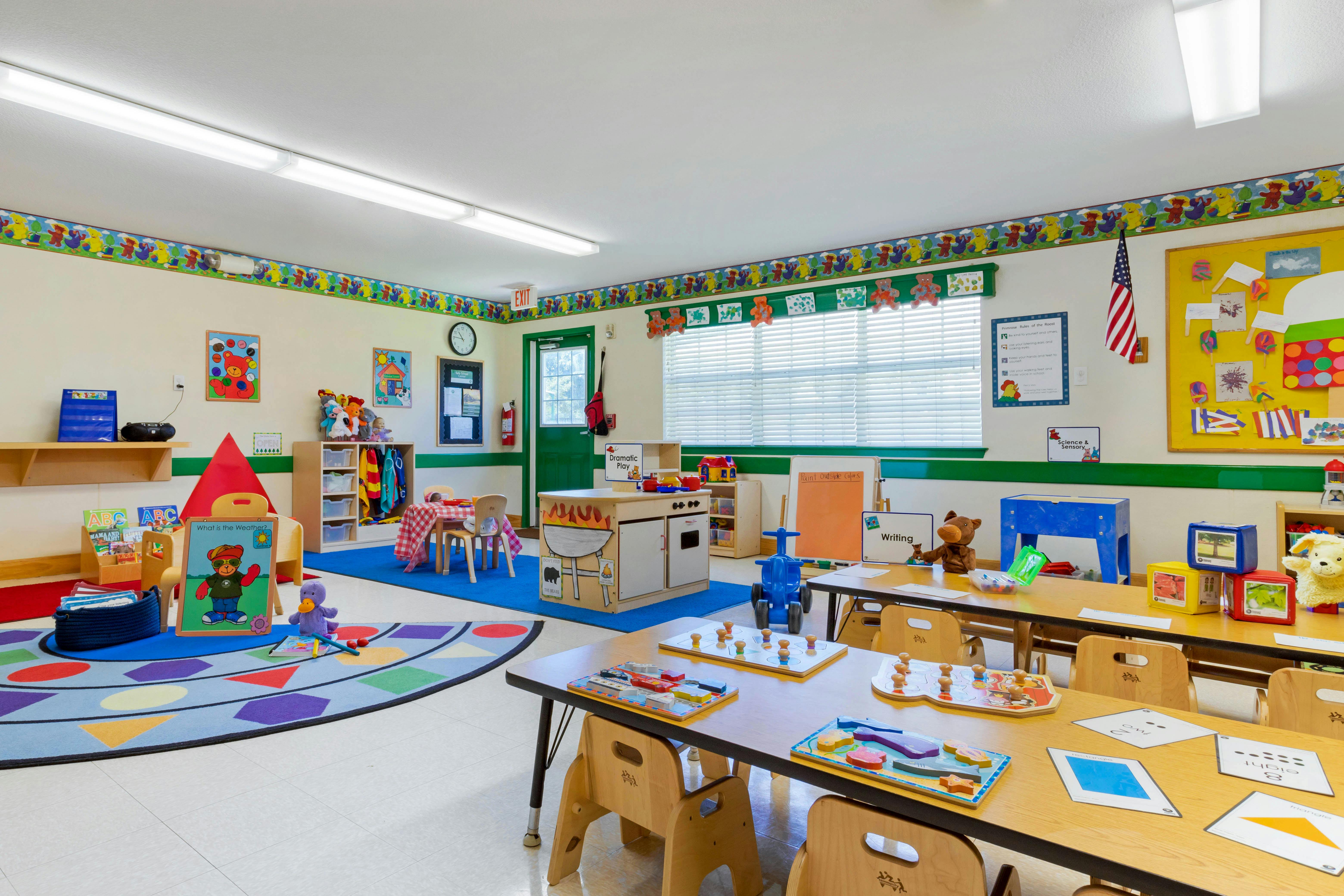Colorful preschool classroom with tables, chairs, and play areas