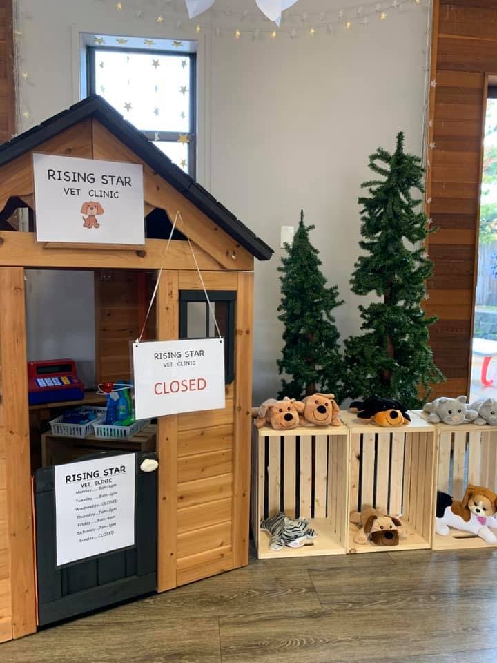Playhouse vet clinic with a "CLOSED" sign and stuffed animals in crates