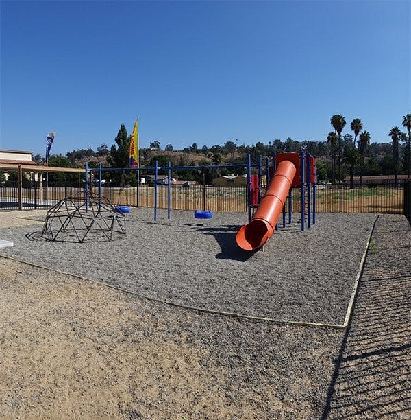 Playground with a slide, swings, and climbing dome