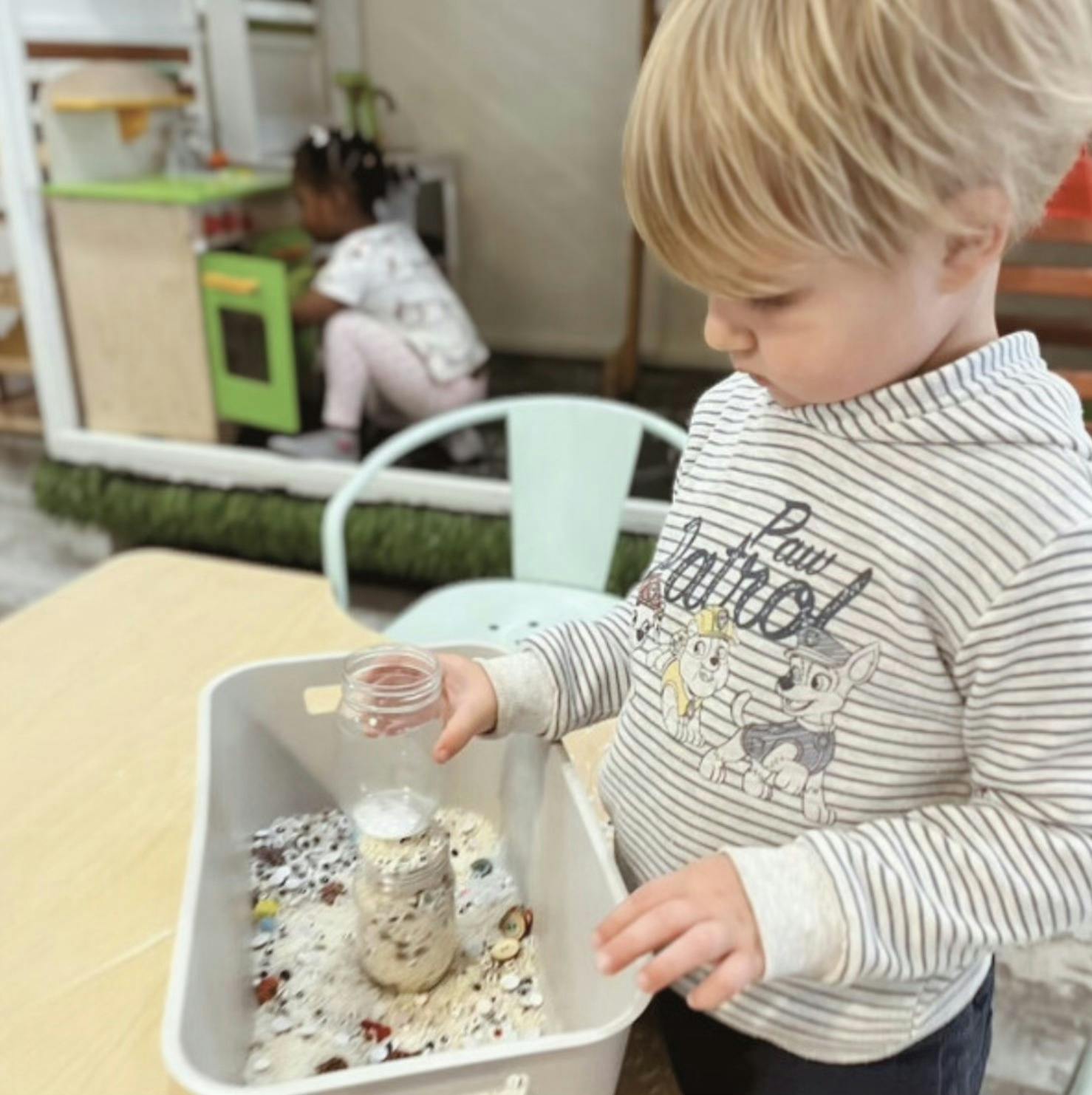 Child playing with sensory bin