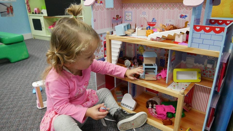Child playing with a dollhouse
