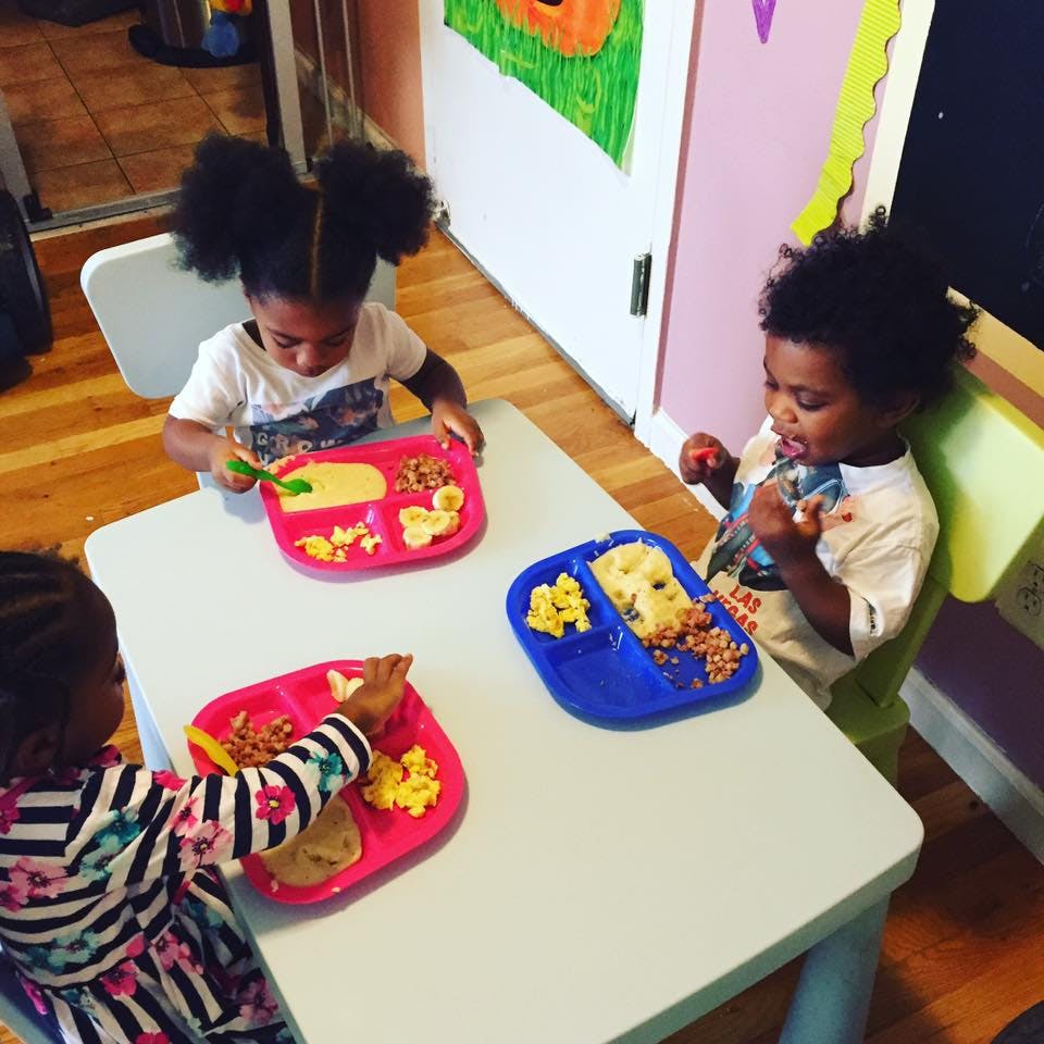 Three children eating meals at a table