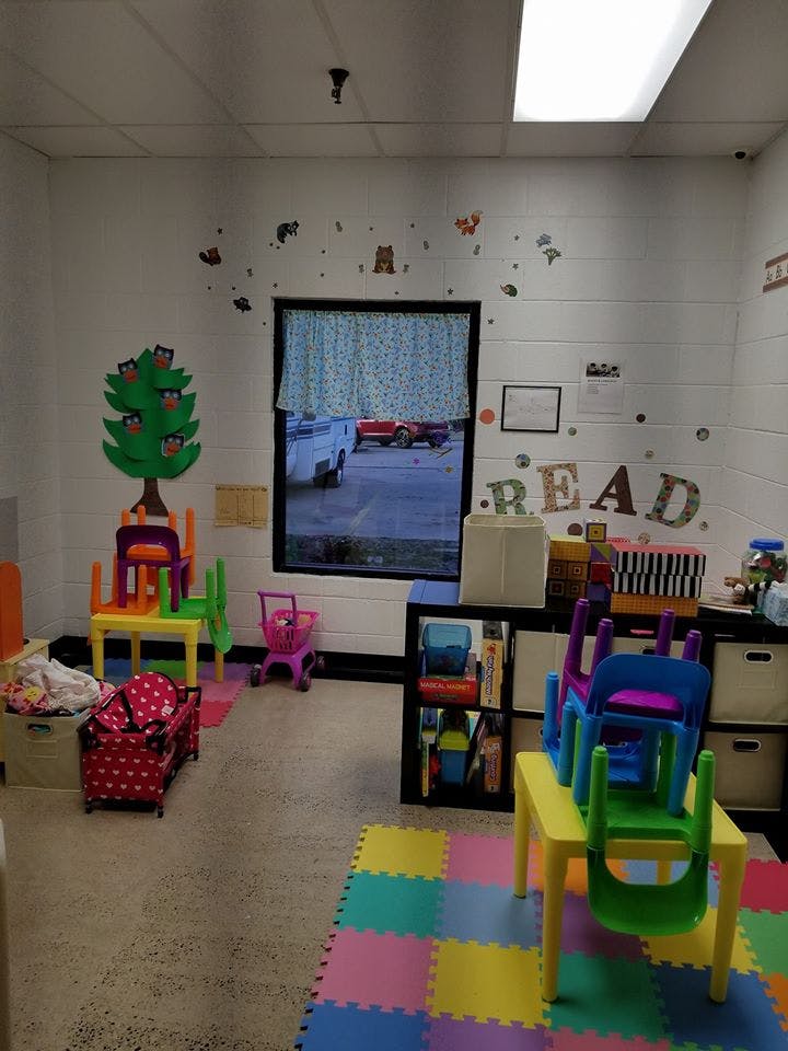 Children's play area with small tables, chairs, and colorful floor mats