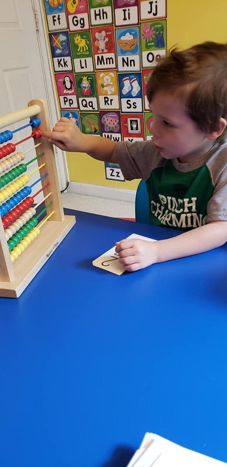 Child using an abacus on a blue table