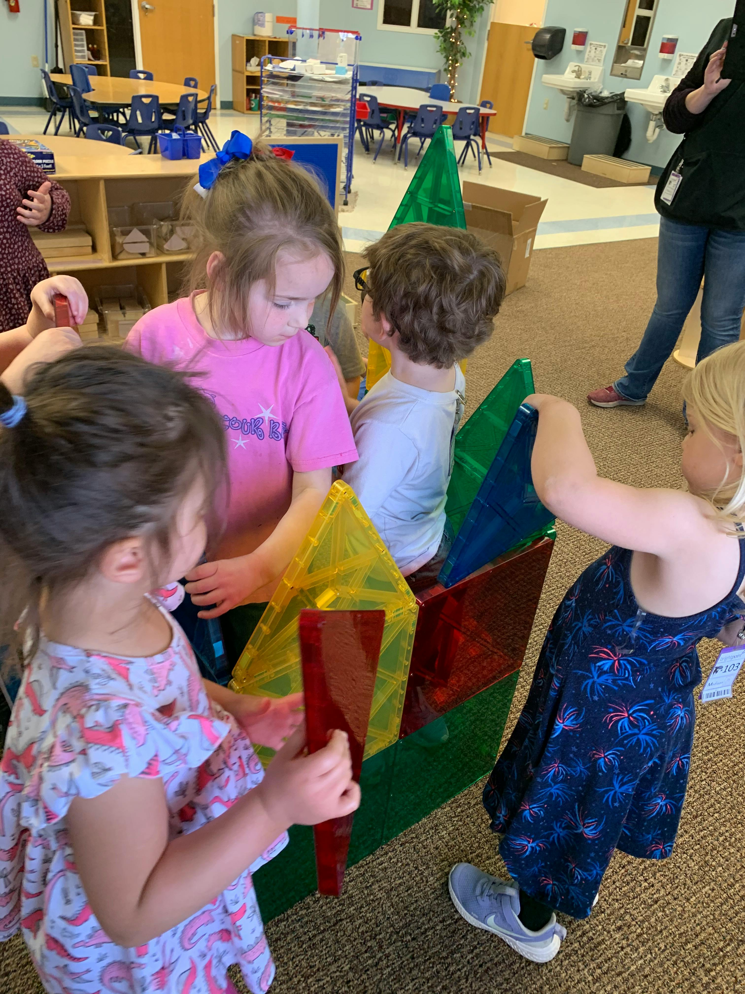 Children playing with colorful magnetic tiles in a classroom