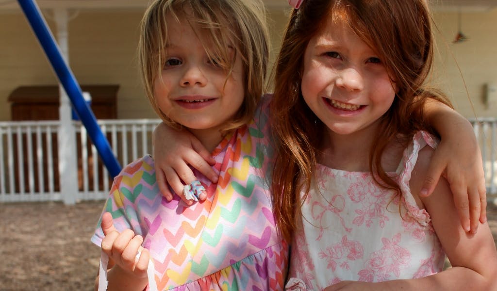 Two children with arms around each other