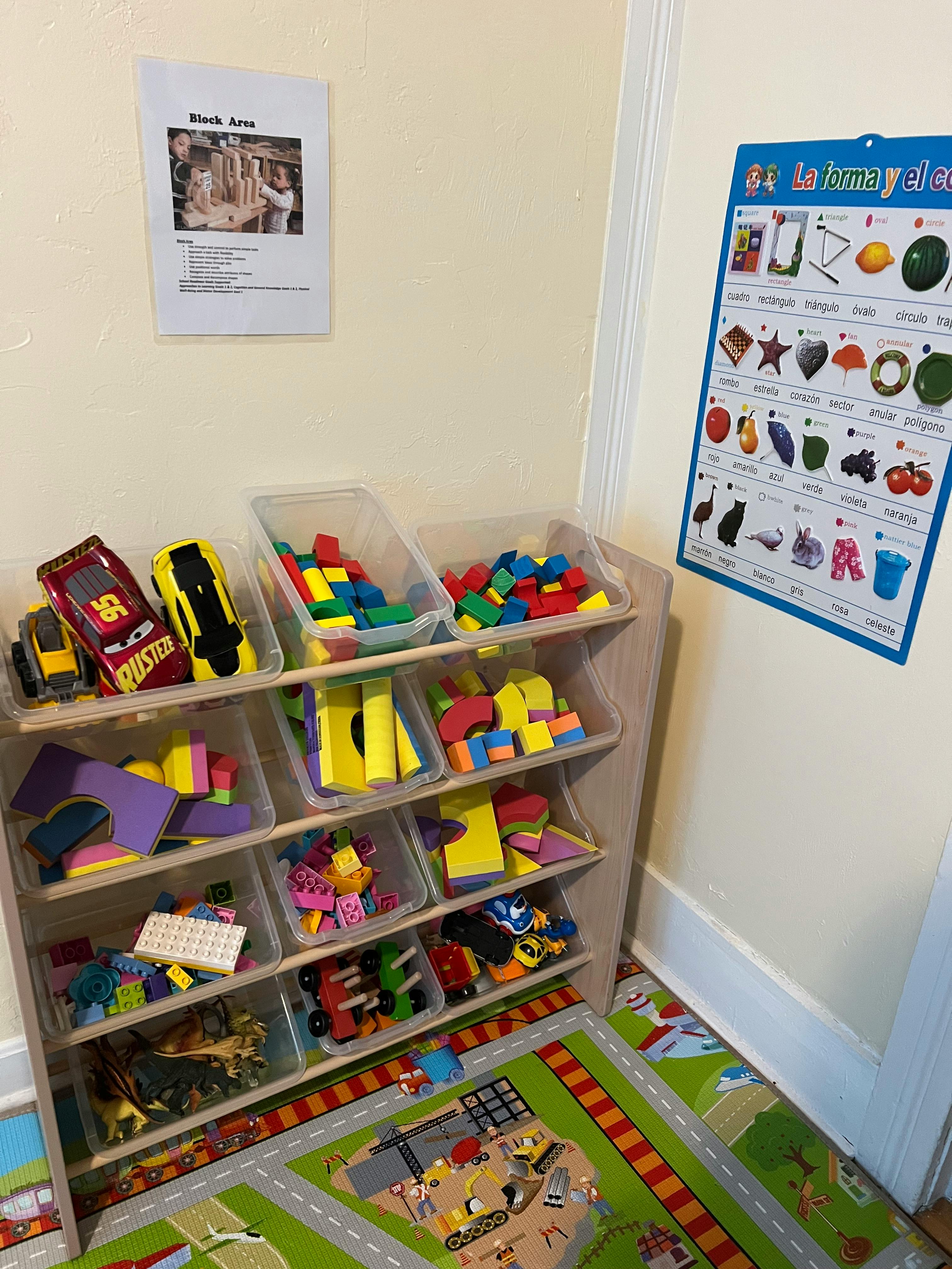 Toy storage shelf with blocks and cars, a playmat on the floor
