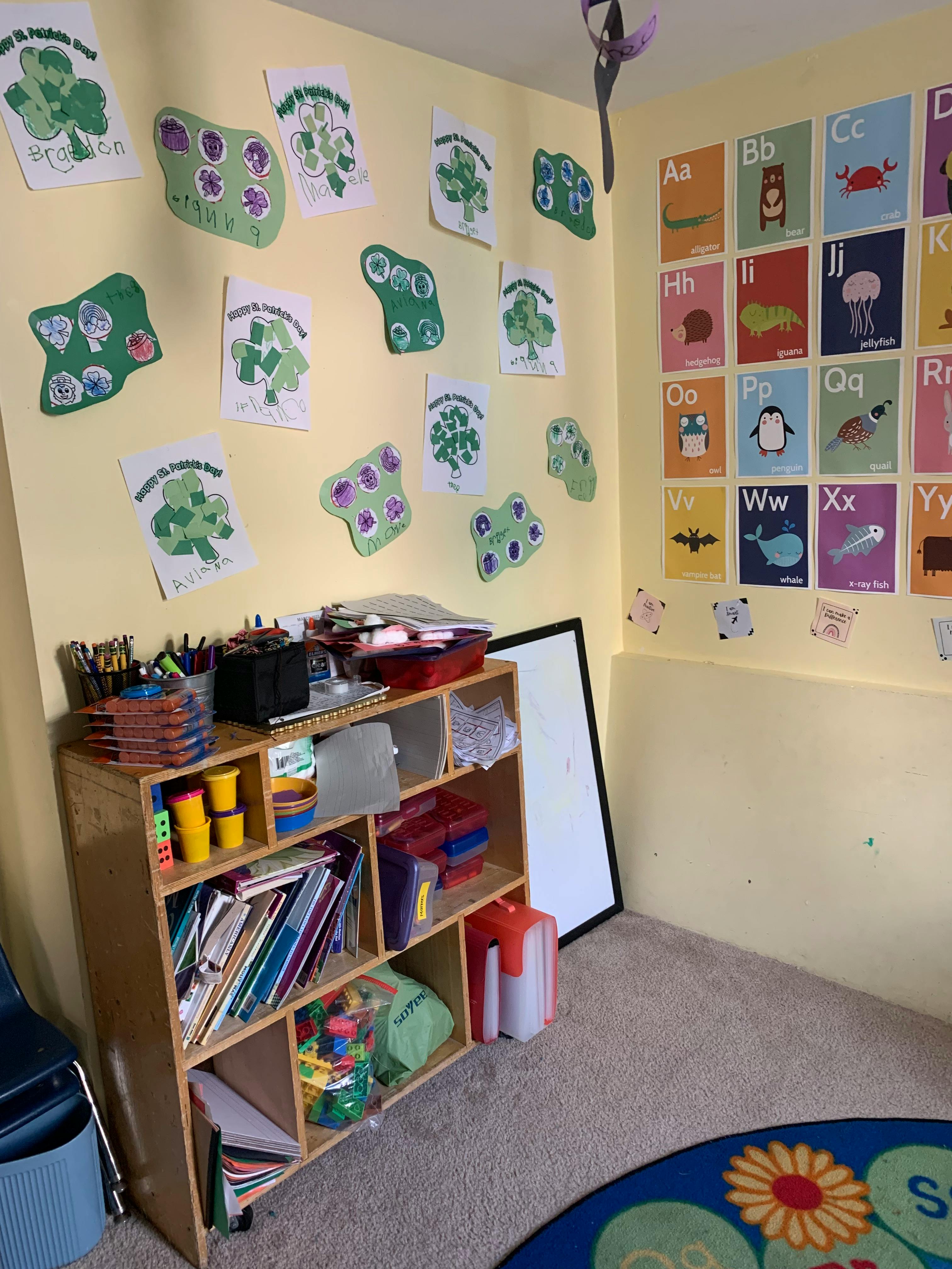 Classroom with alphabet chart, shamrock cutouts, and a wooden shelf