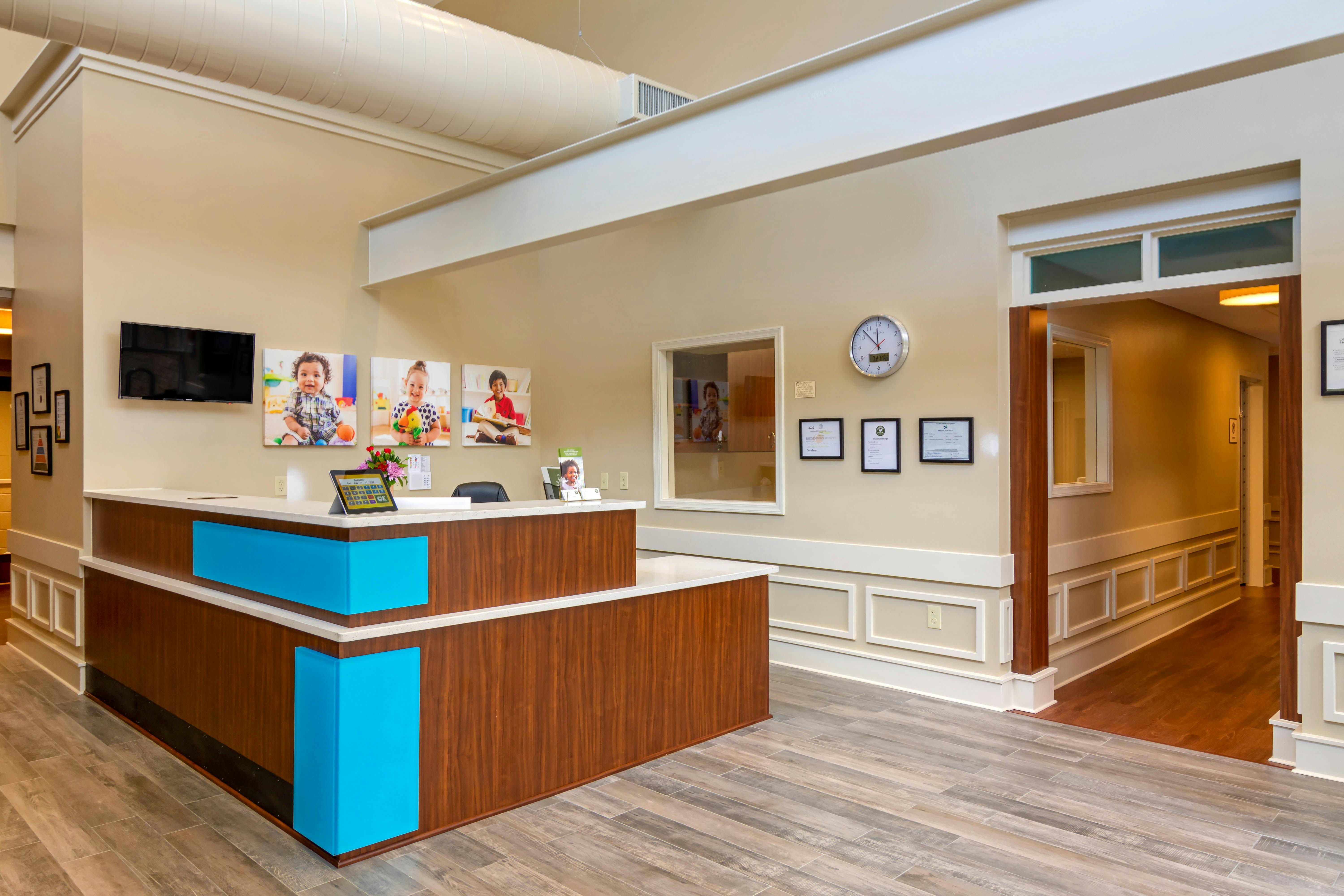 Reception desk with photos of children on the wall