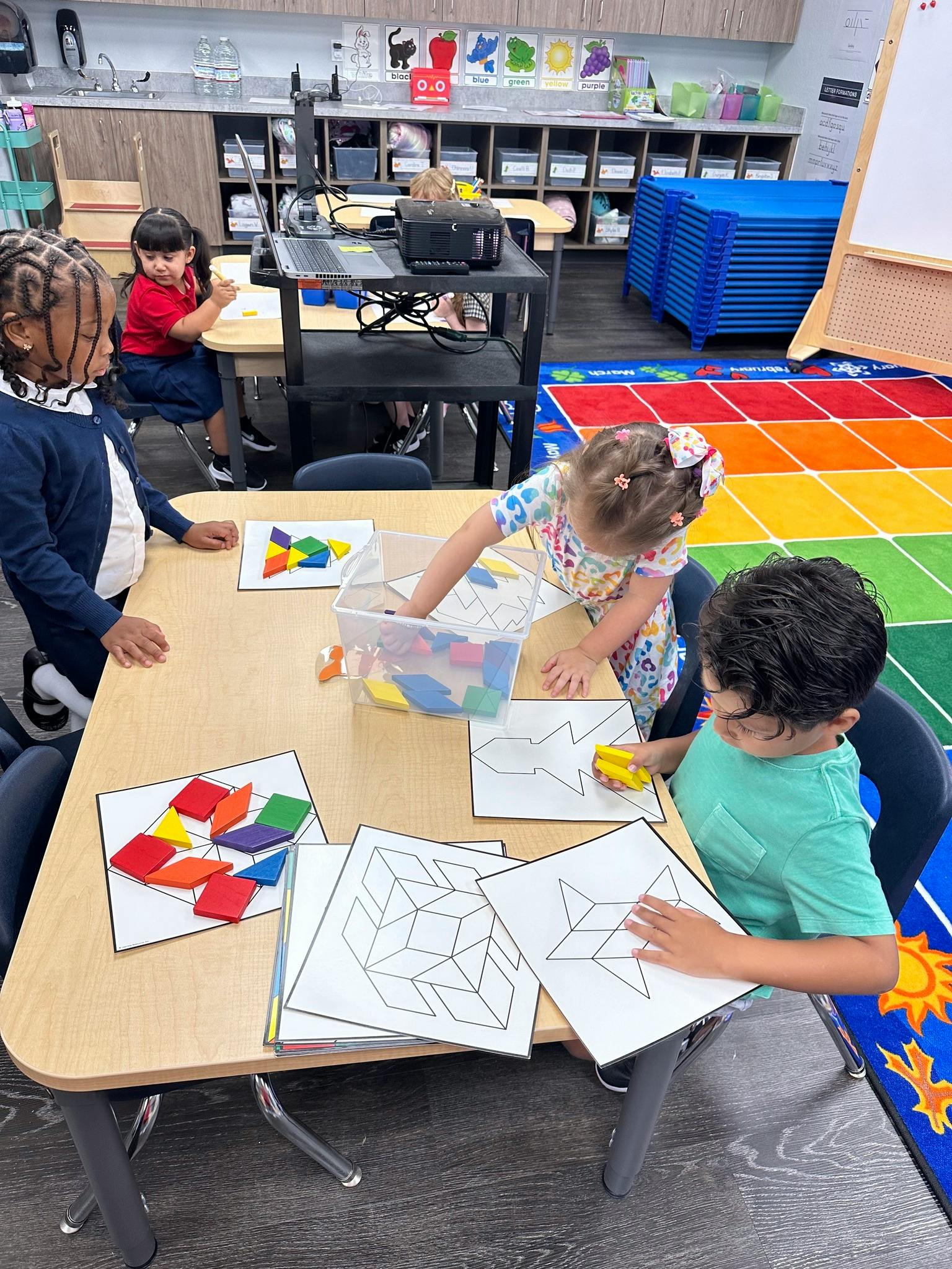 Children playing with pattern blocks and drawing in a classroom