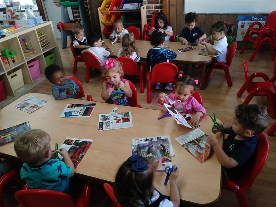 Children sitting at tables doing crafts