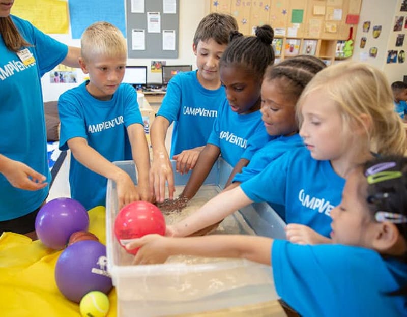 Children playing with balls in a sensory bin