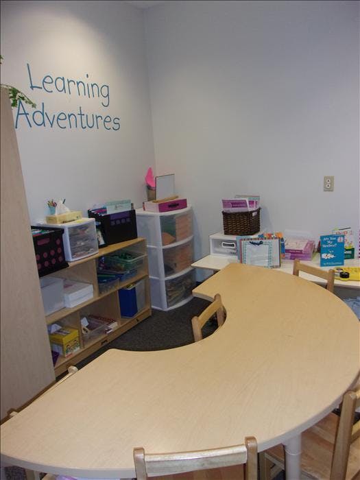 Learning Adventures text on a wall in a room with a curved table and shelves