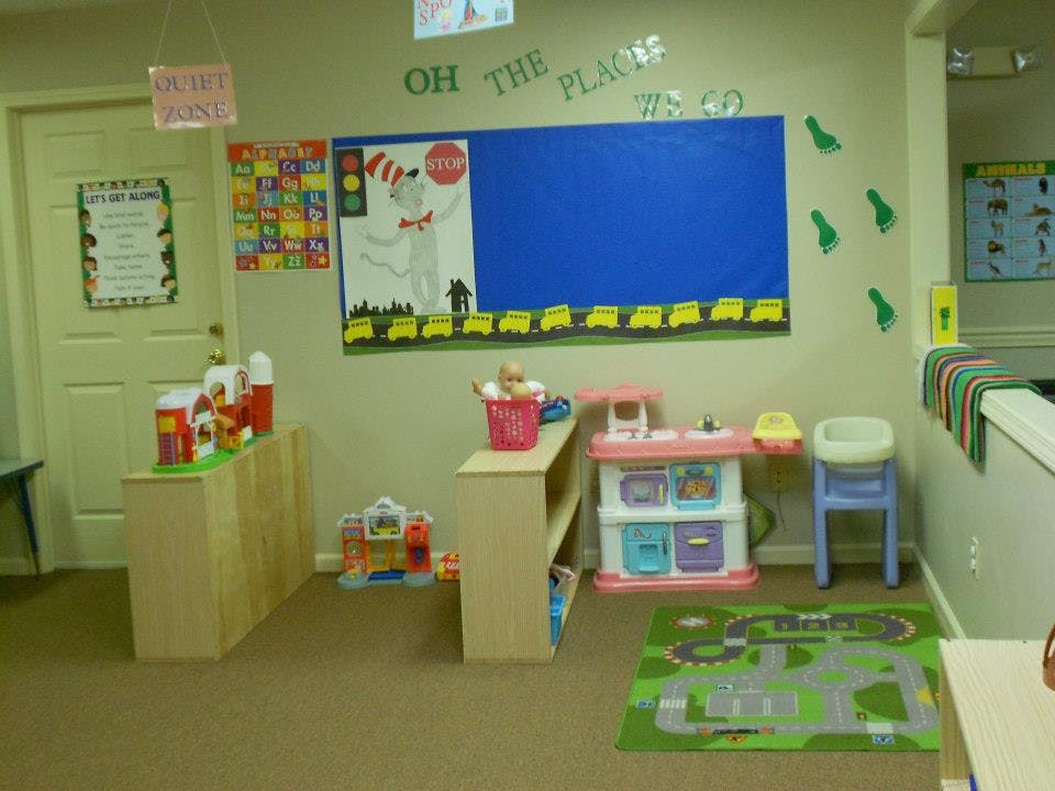 Children's play area with toys, shelves, and a bulletin board