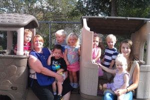 Adults and children playing on outdoor play equipment