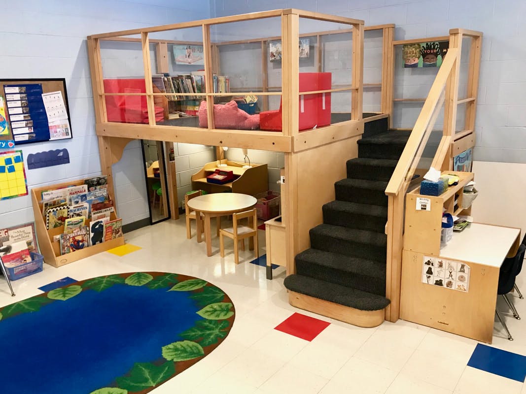 Indoor play area with a loft, stairs, and a blue rug