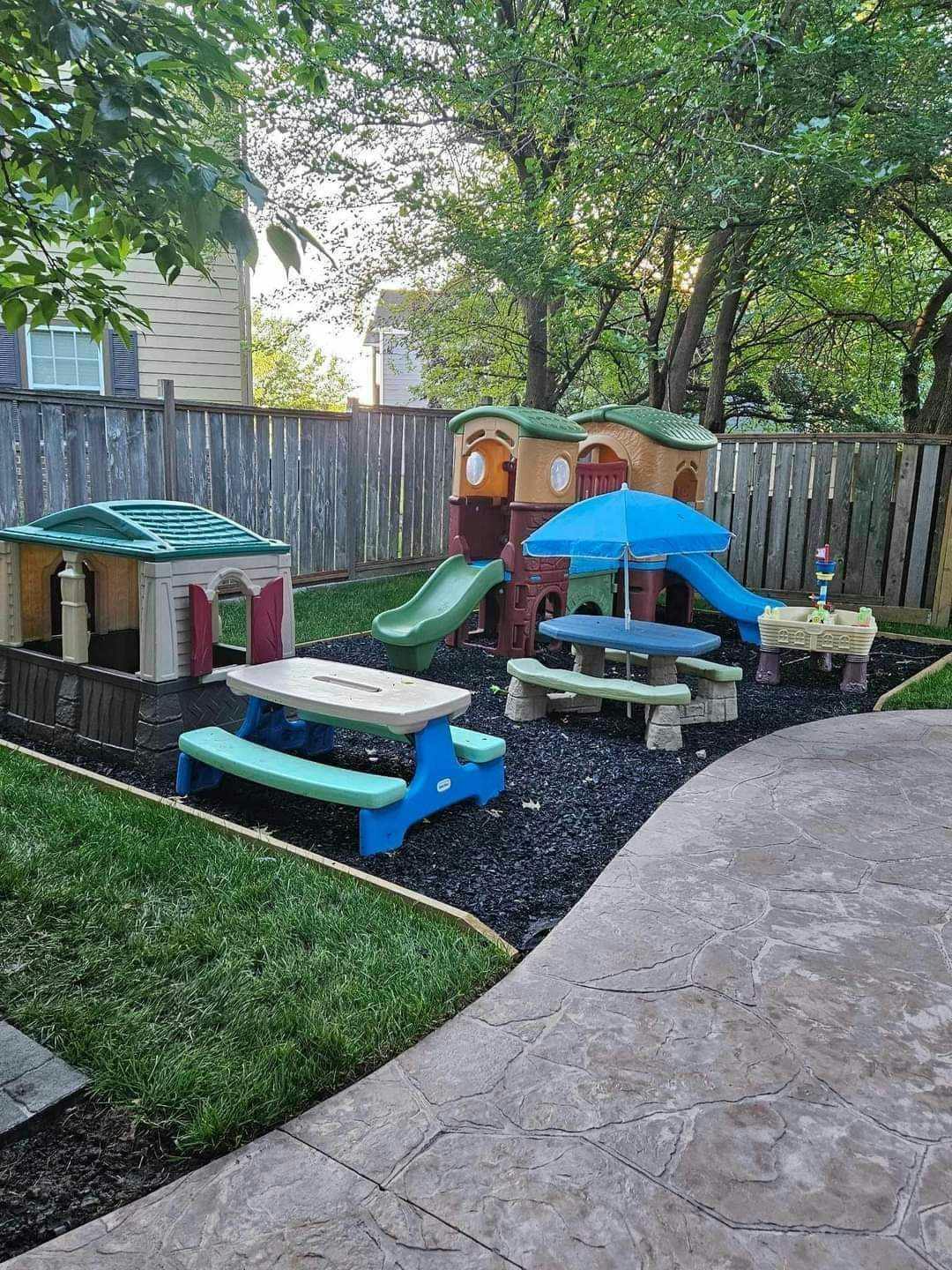 Outdoor play area with playhouses, slides, and picnic tables