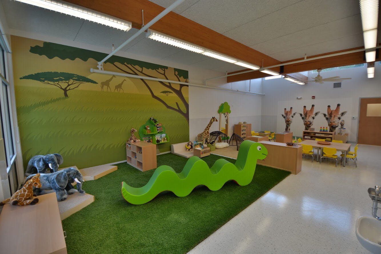Playroom with safari-themed wall mural, green snake-shaped climbing toy