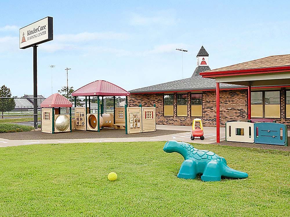 KinderCare Learning Center building and outdoor playground with toys