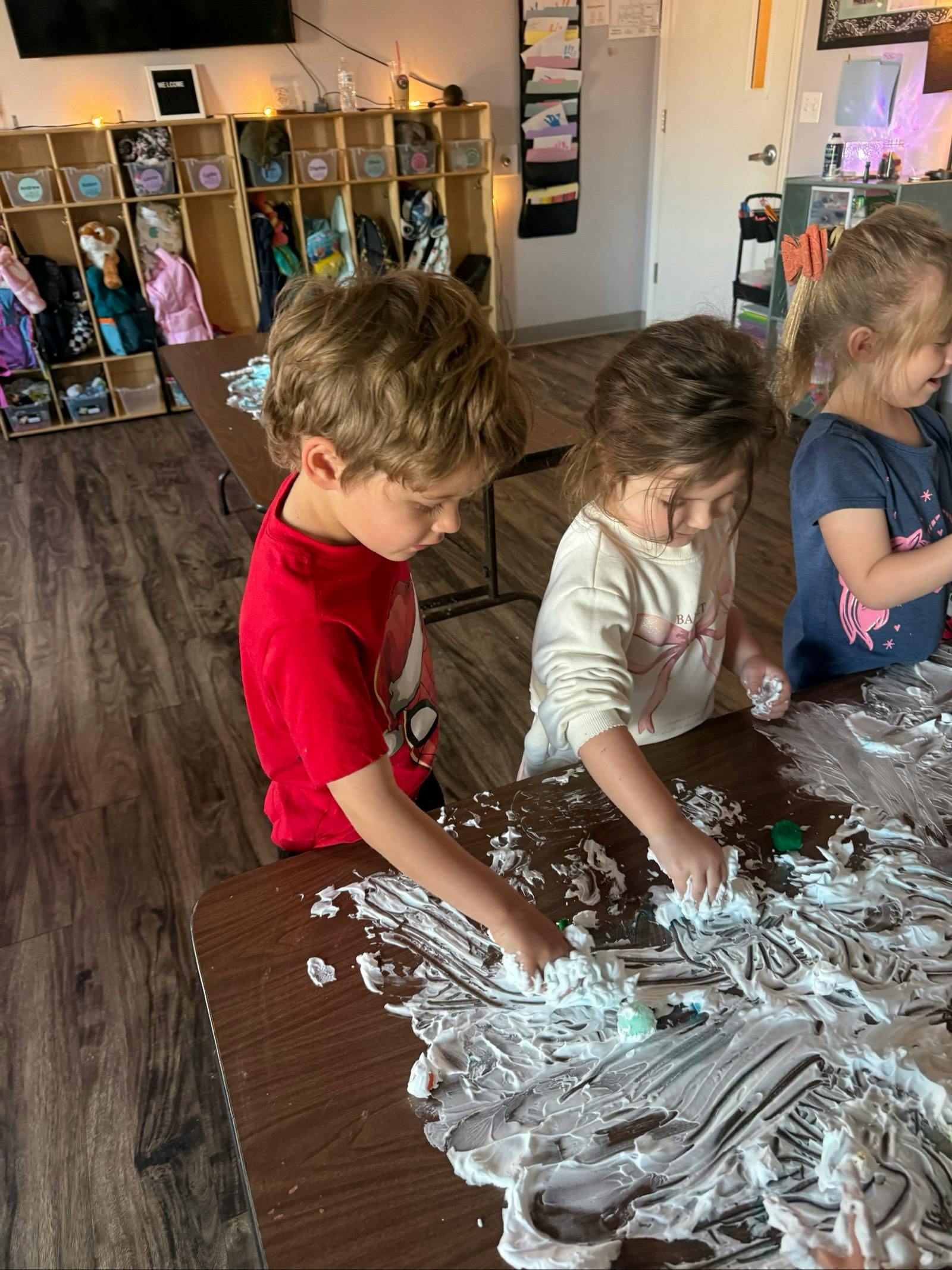 Children playing with shaving cream on a table