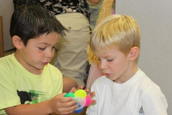 Two children looking at a colorful toy