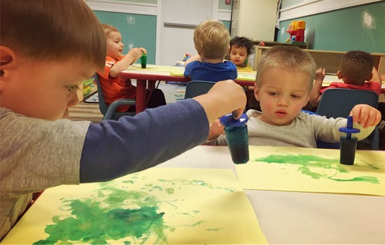 Children painting with droppers in a classroom