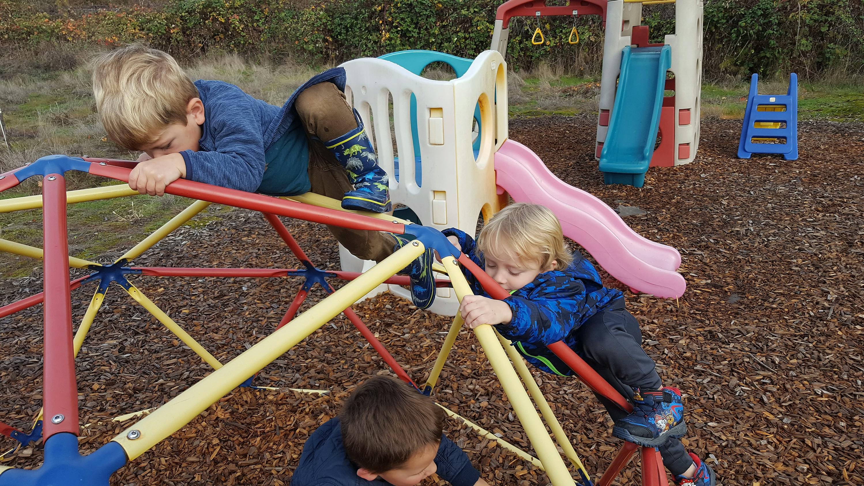 Children climbing on a playground dome climber