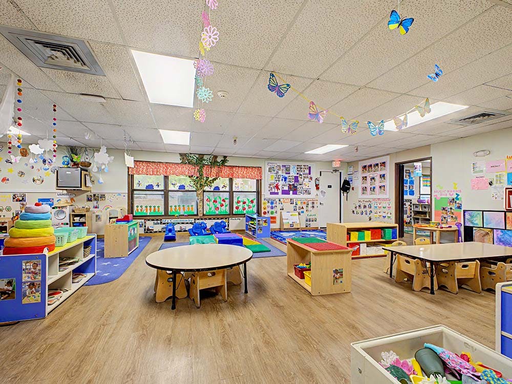 Colorful and organized classroom with tables, shelves, and decorations