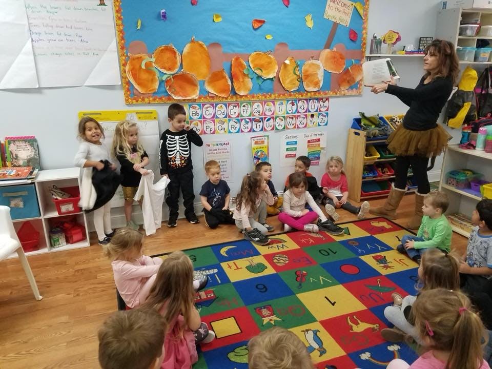 Adult reading to children in a classroom