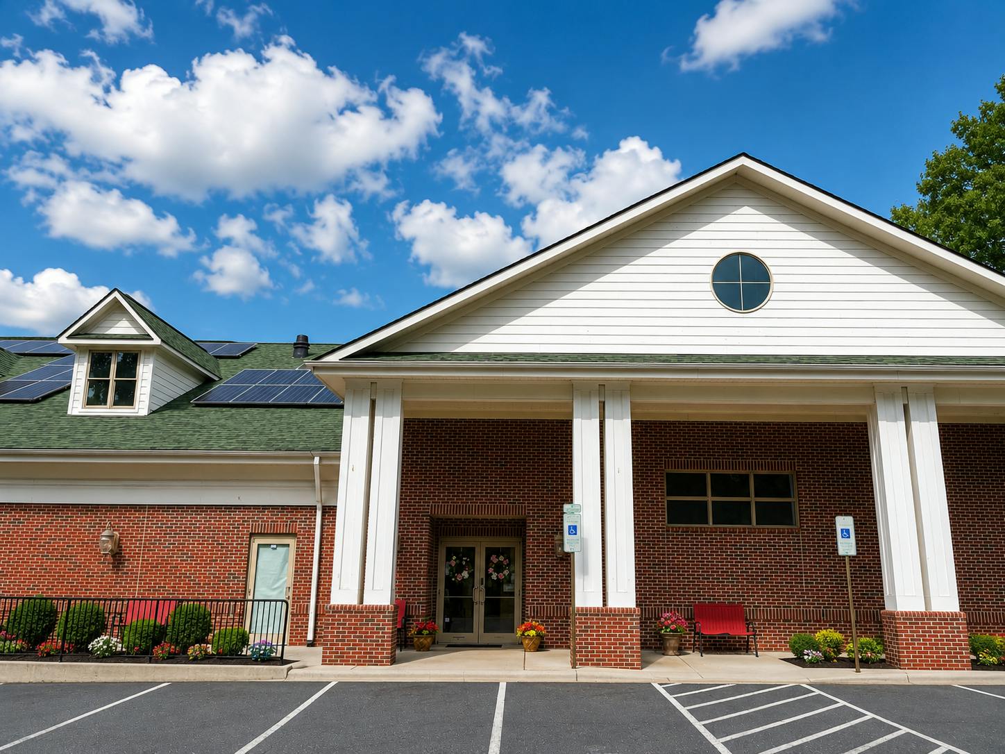 Entrance of a brick building with white pillars and solar panels on the roof