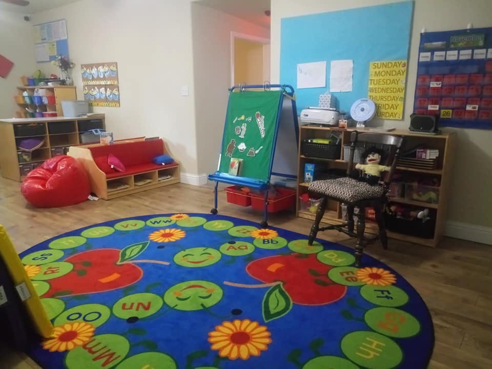 Classroom with a colorful rug, easel, and seating